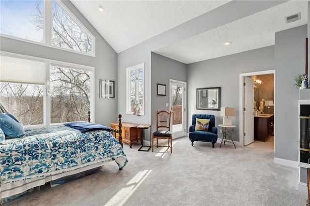 bedroom with light carpet, multiple windows, connected bathroom, and high vaulted ceiling