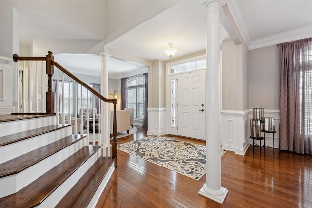 foyer featuring ornamental molding, dark hardwood / wood-style flooring, and ornate columns