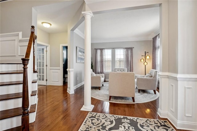 entryway with dark hardwood / wood-style flooring, ornamental molding, and ornate columns