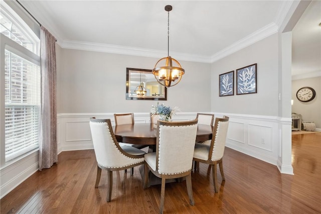 dining area with ornamental molding, hardwood / wood-style floors, and a notable chandelier