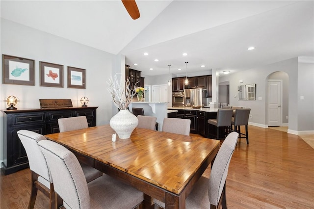 dining area featuring vaulted ceiling, ceiling fan, and light wood-type flooring