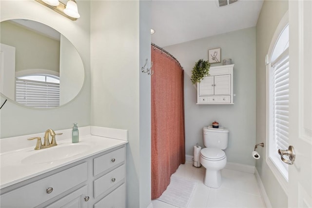 bathroom featuring tile patterned floors, vanity, toilet, and a wealth of natural light