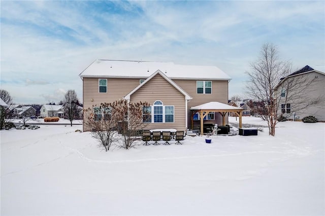 snow covered rear of property featuring a gazebo