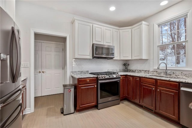 kitchen featuring white cabinetry, appliances with stainless steel finishes, backsplash, and sink