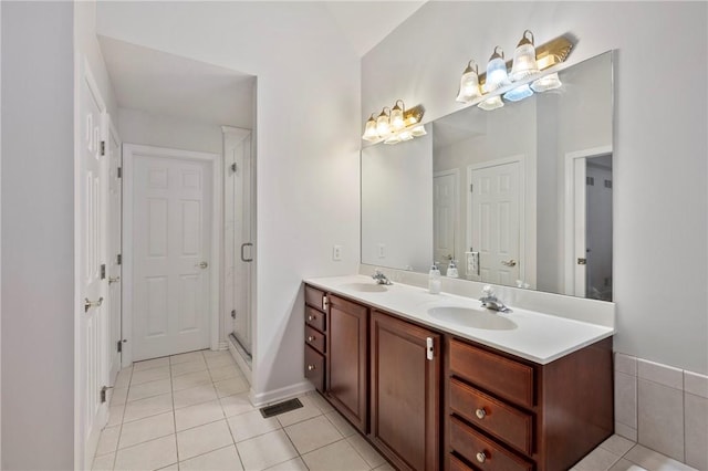 bathroom featuring walk in shower, vanity, and tile patterned flooring