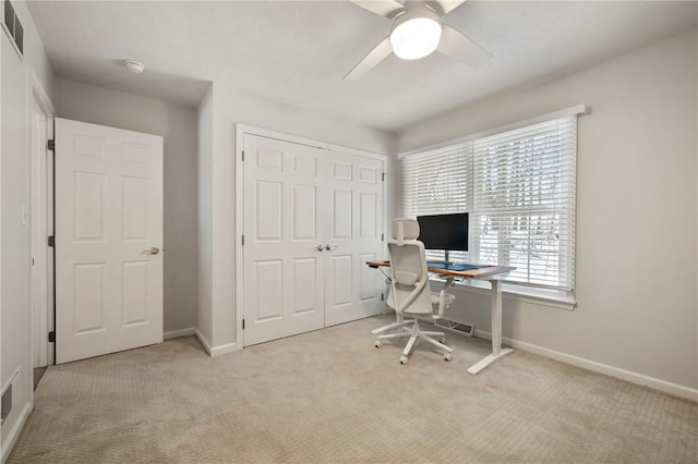 carpeted office space featuring ceiling fan