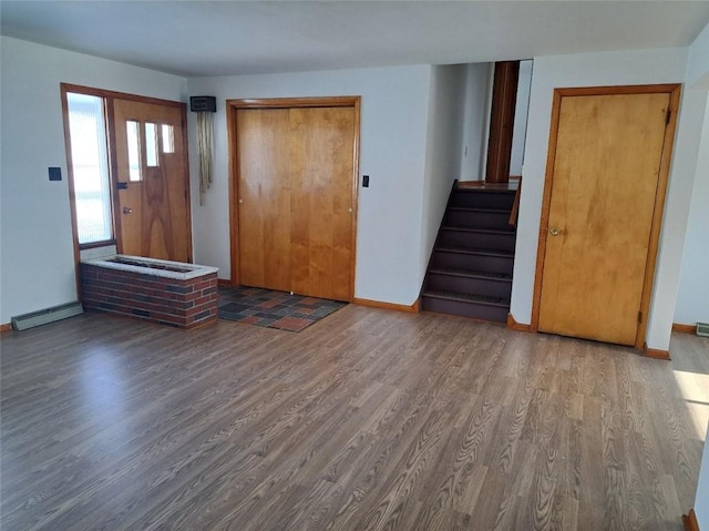 foyer entrance featuring a baseboard heating unit and wood-type flooring