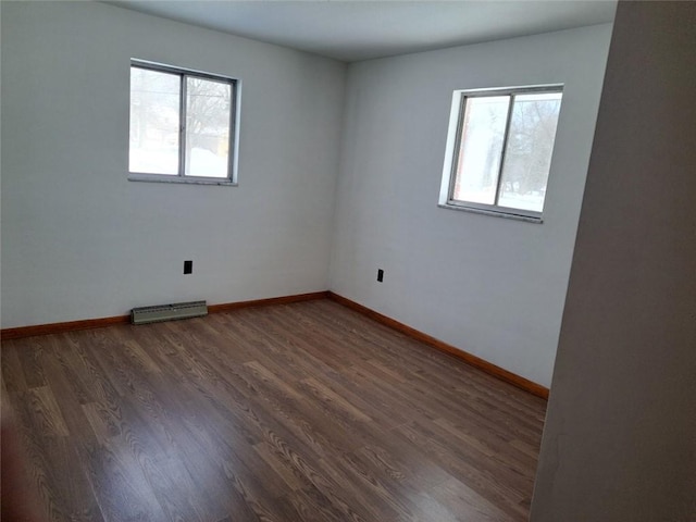 unfurnished room with dark wood-type flooring