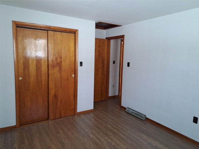 unfurnished bedroom with a closet and dark hardwood / wood-style flooring