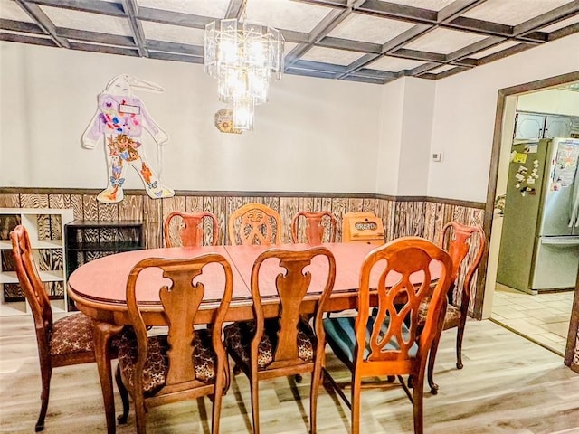 dining room with light wood-type flooring, beam ceiling, and coffered ceiling