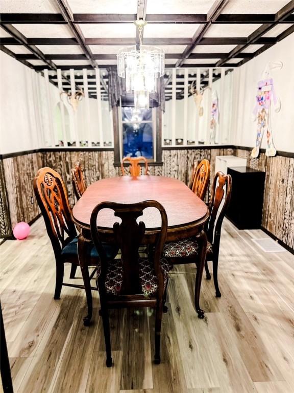 dining room with beamed ceiling, coffered ceiling, and hardwood / wood-style floors