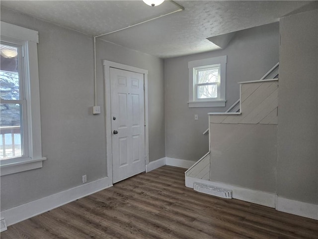 foyer featuring dark wood-type flooring and a textured ceiling