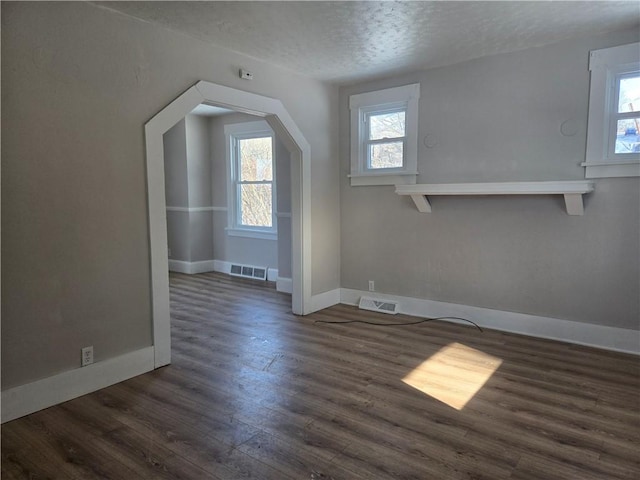 additional living space with a textured ceiling and dark hardwood / wood-style flooring