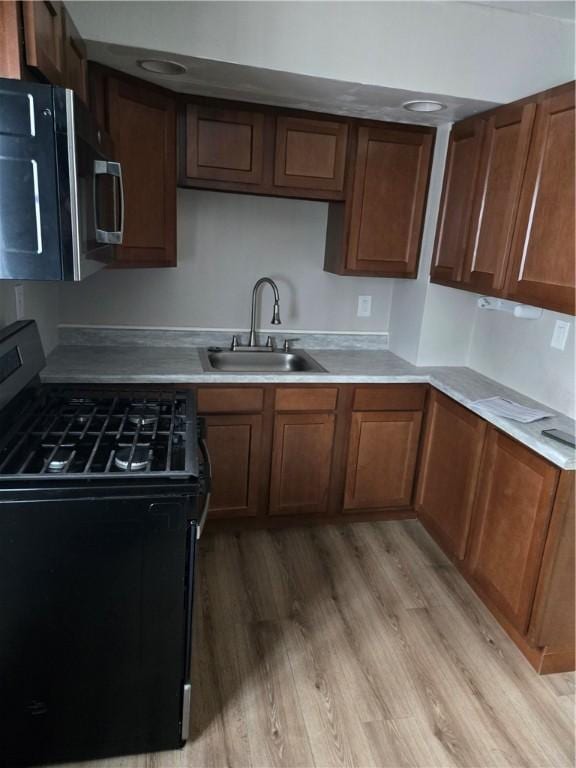 kitchen with sink, light hardwood / wood-style flooring, and black range with gas cooktop