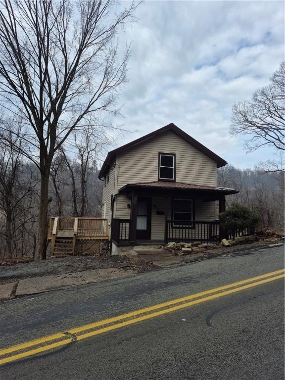 view of front of house featuring covered porch and a wooden deck