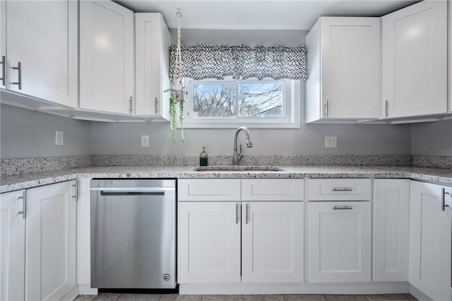 kitchen featuring white cabinets, dishwasher, sink, and light stone counters