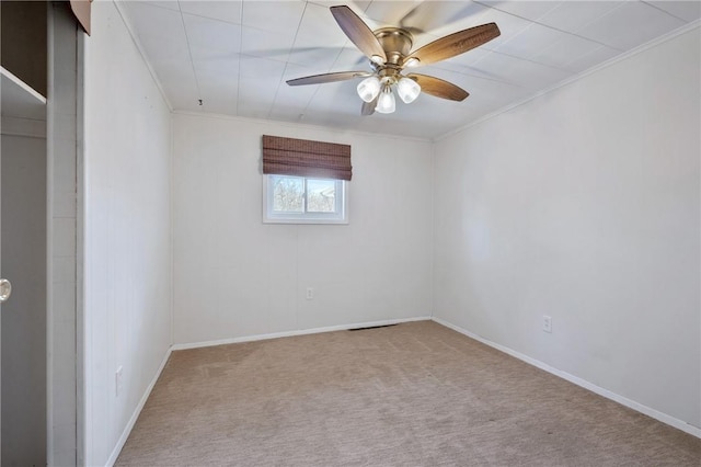 spare room featuring light carpet, ceiling fan, and ornamental molding