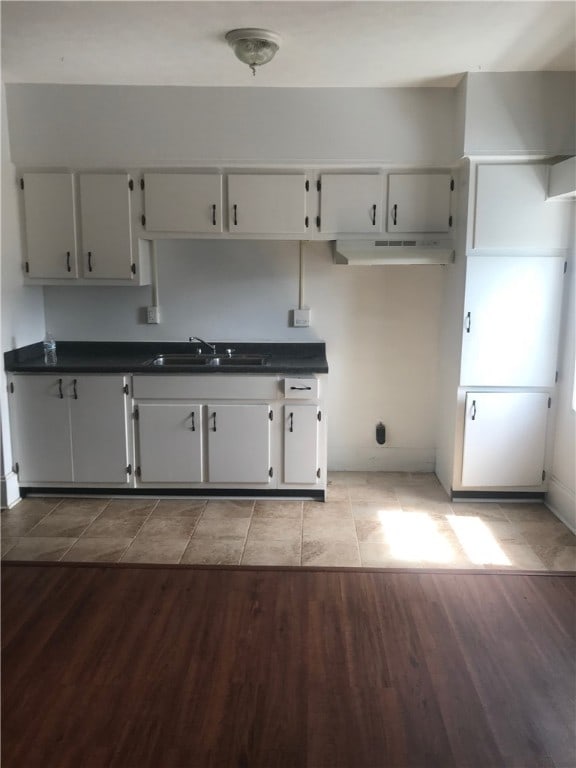 kitchen with light hardwood / wood-style floors, sink, and white cabinets