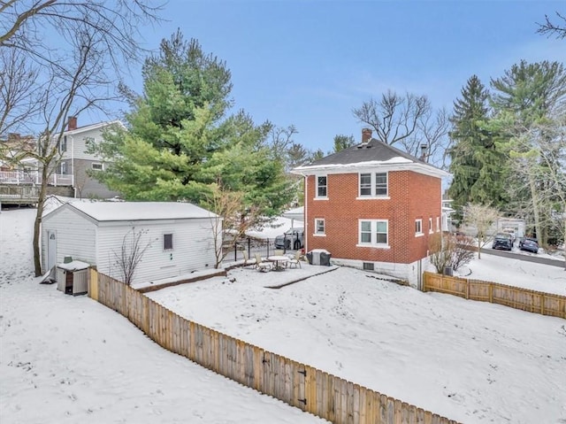 view of snow covered back of property