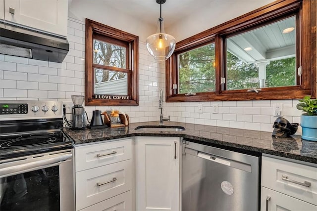 kitchen featuring tasteful backsplash, white cabinets, and appliances with stainless steel finishes