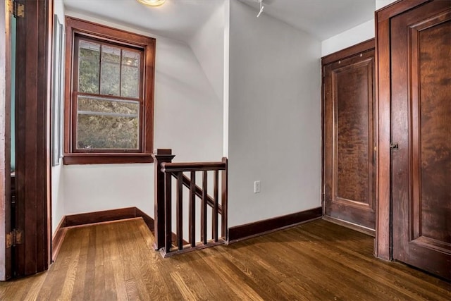 hall featuring vaulted ceiling and dark hardwood / wood-style floors