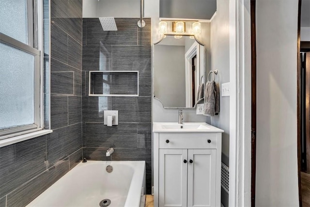 bathroom with tiled shower / bath combo and vanity