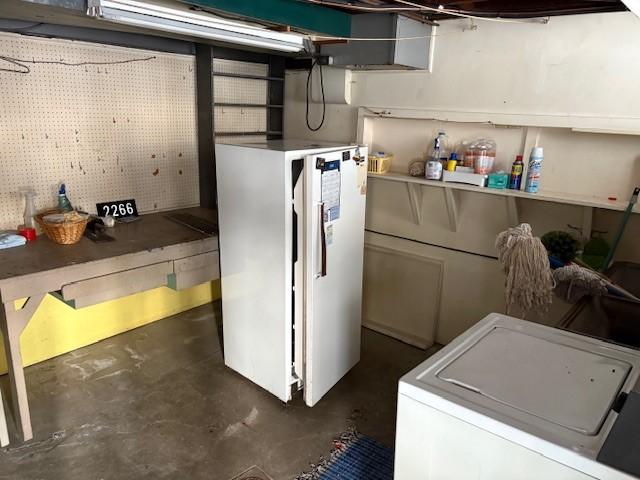 basement with washer / dryer and white refrigerator