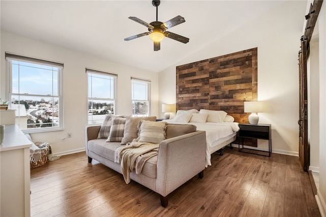 bedroom with ceiling fan, wood-type flooring, vaulted ceiling, and multiple windows