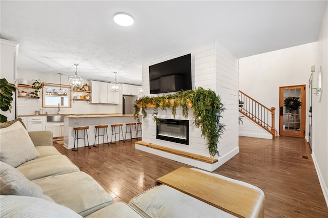 living room with dark hardwood / wood-style floors, sink, and a notable chandelier