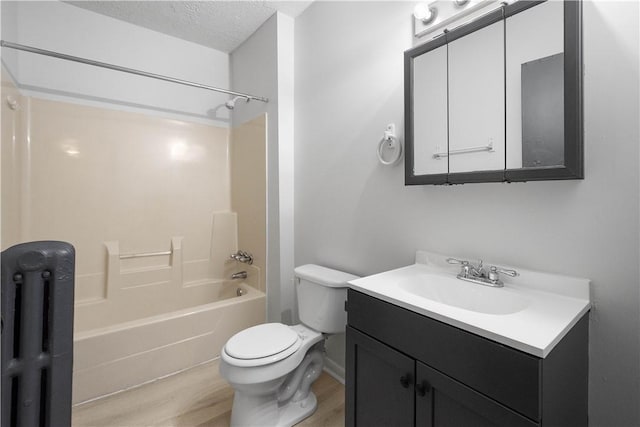 full bathroom with a textured ceiling, hardwood / wood-style floors, bathing tub / shower combination, vanity, and toilet