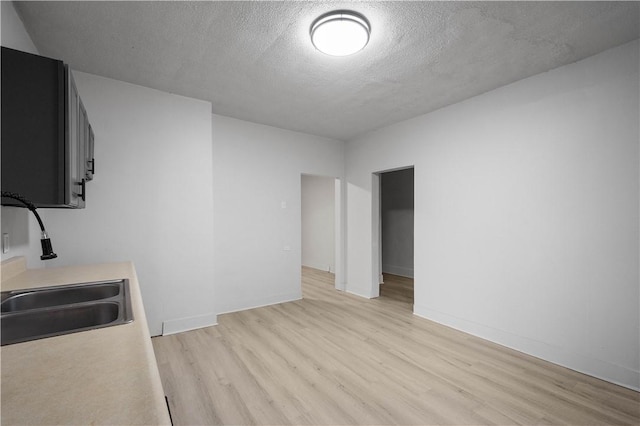 interior space featuring a textured ceiling, light hardwood / wood-style floors, and sink