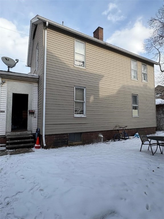 view of snow covered rear of property