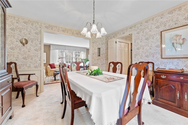 carpeted dining room with a chandelier and ornamental molding