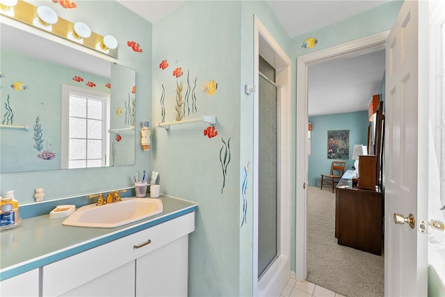 bathroom featuring tile patterned floors, a shower with shower door, and vanity