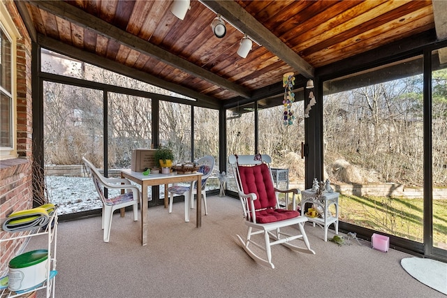 unfurnished sunroom with vaulted ceiling with beams, a wood stove, and wooden ceiling