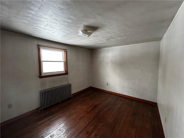 empty room featuring radiator and dark wood-type flooring