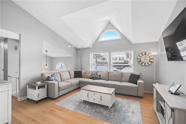 living room featuring lofted ceiling and light hardwood / wood-style flooring