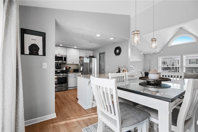 dining area with lofted ceiling and light hardwood / wood-style flooring