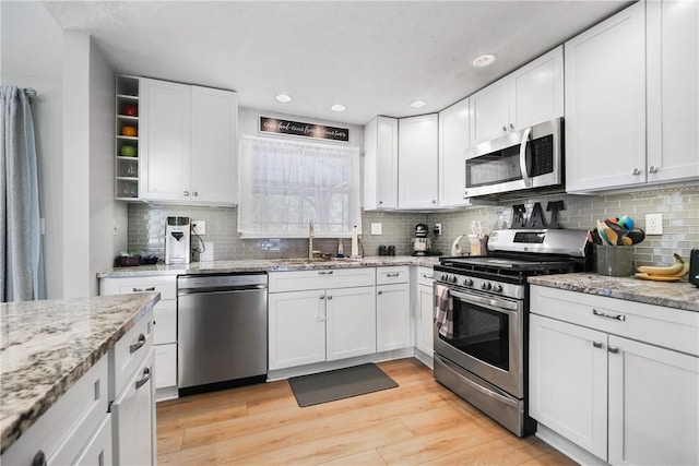 kitchen featuring stainless steel appliances, white cabinets, and sink