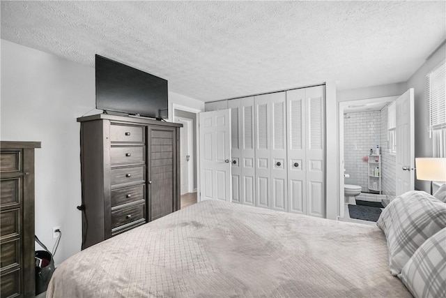 bedroom featuring a textured ceiling, a closet, and ensuite bath