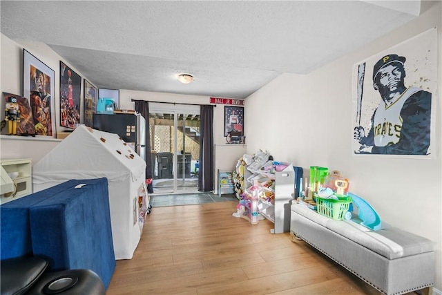 game room with a textured ceiling and hardwood / wood-style floors