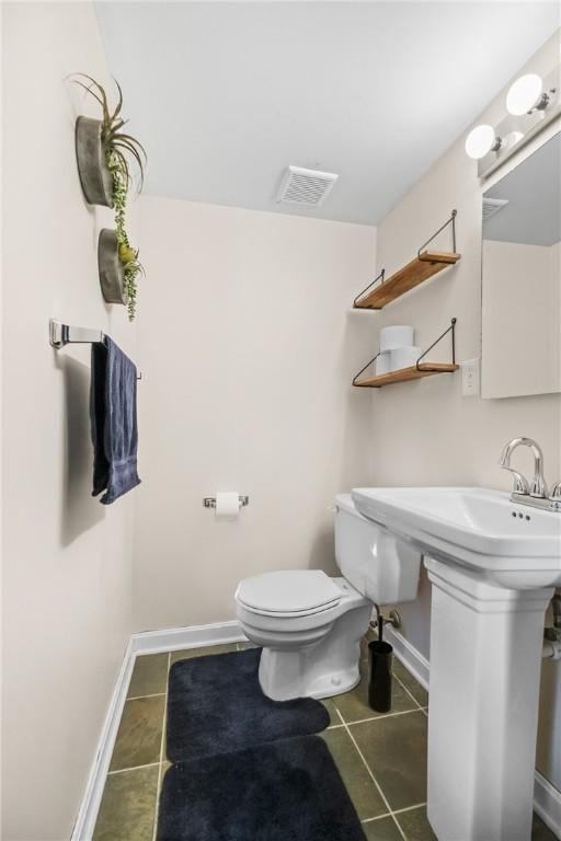 bathroom featuring toilet and tile patterned flooring