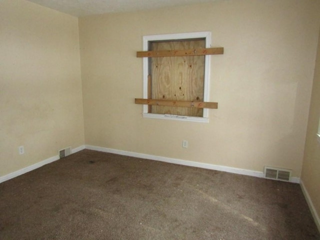 unfurnished room featuring dark carpet