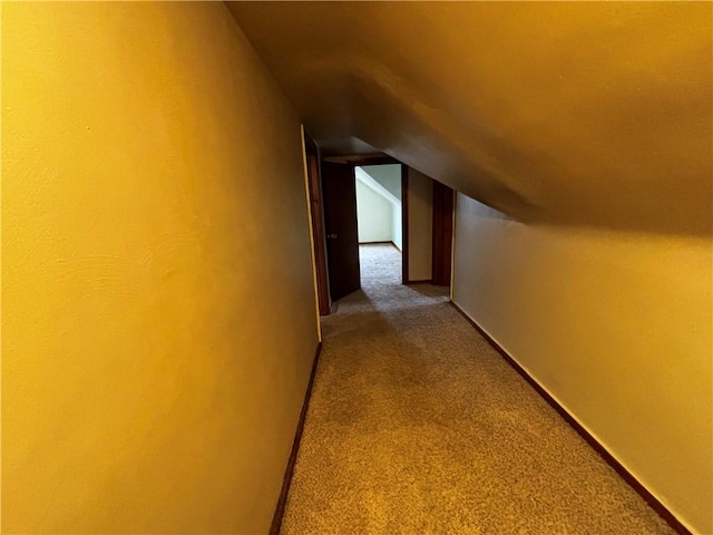 hallway featuring carpet flooring and lofted ceiling