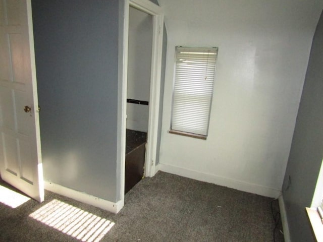 hall with dark colored carpet