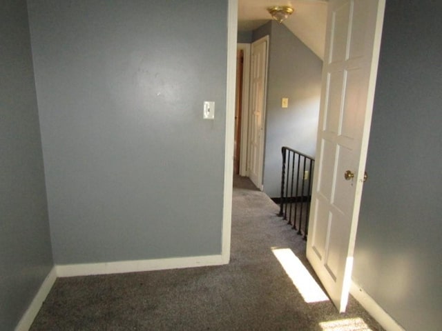 hall with dark colored carpet