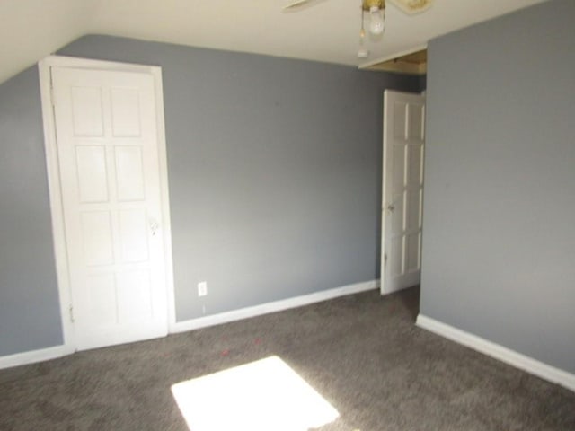 unfurnished bedroom featuring vaulted ceiling, ceiling fan, and dark carpet