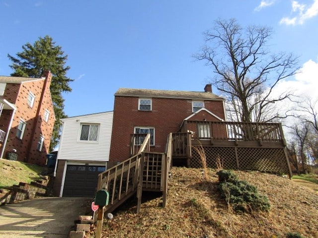 back of house featuring a garage and a wooden deck