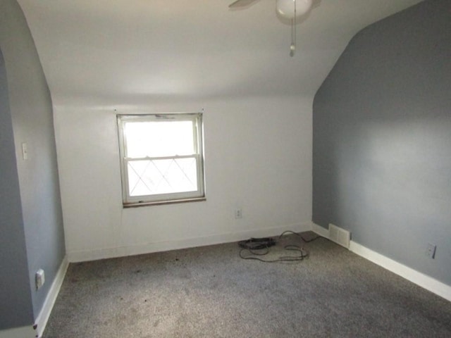 carpeted spare room with vaulted ceiling and ceiling fan