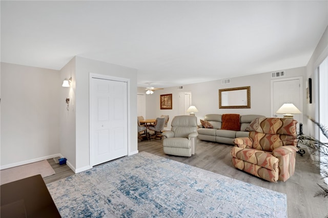 living room with light hardwood / wood-style floors and ceiling fan